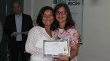 Servidora Joelma Dornelas recebendo o diploma das mãos da coordenadora do PPA Luciana Nery